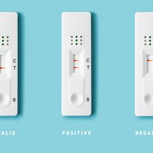 Three covid rapid antigen tests displaying (left to right) invalid, positive, and negative results.