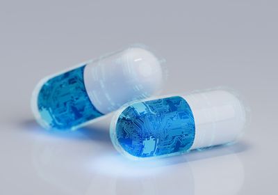 Conceptional image of two pills covered with a circuit-board pattern.