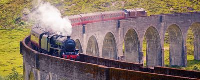 A steam train going over a viaduct.