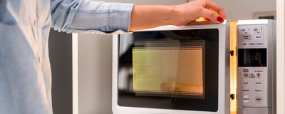 Image of a person closing a microwave oven door