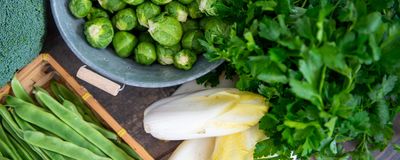 Image of Brussels sprouts and endives on a wooden background.