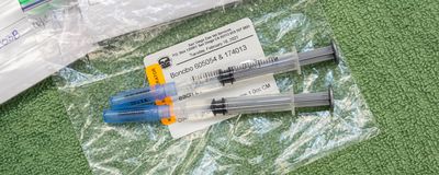 Two vaccine syringes on a baggy labelled with San Diego Zoo and Bonobo