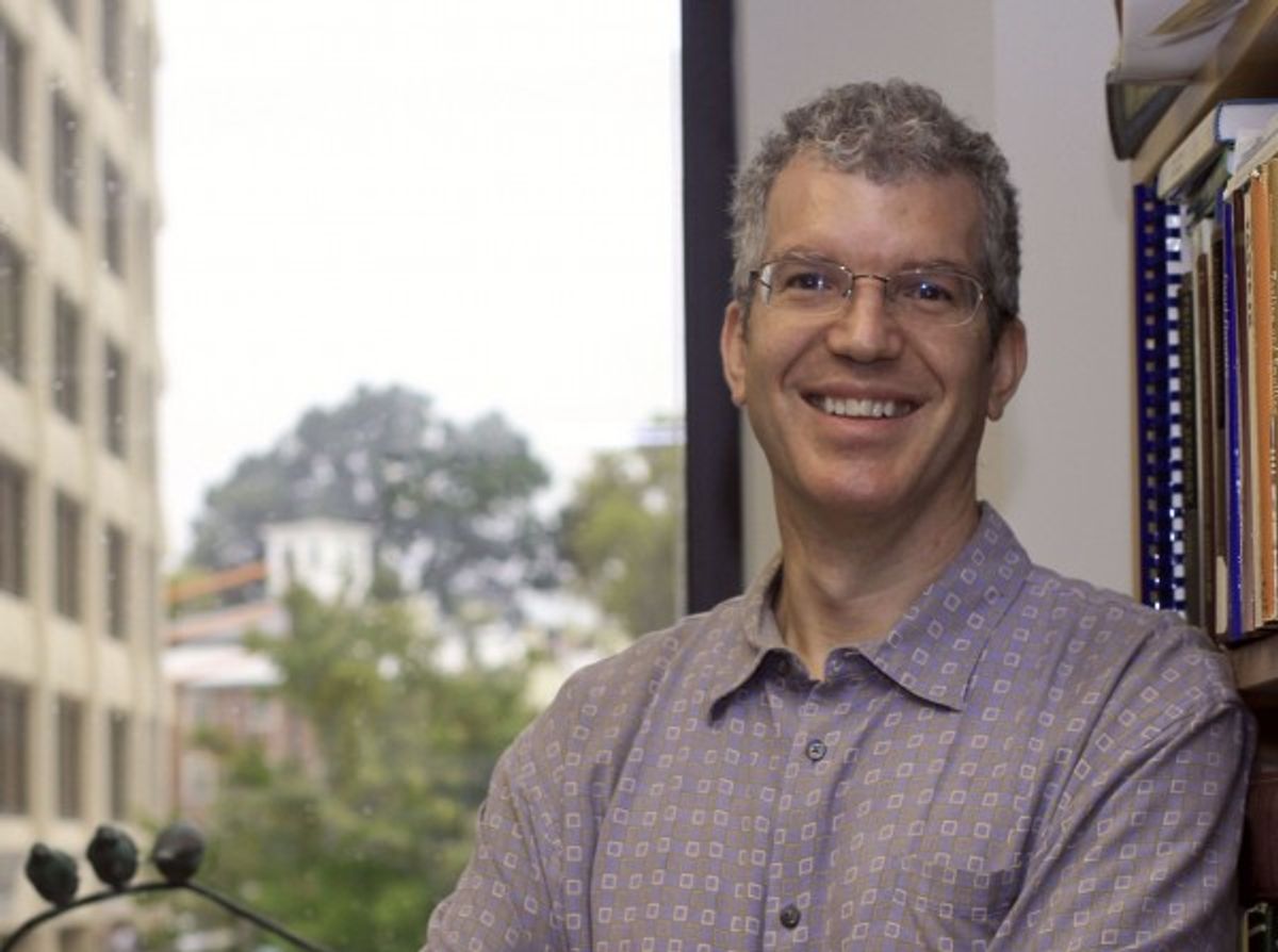 Image of Paul Breslin. He is wearing glasses and a patterned shirt and smiles at the camera.