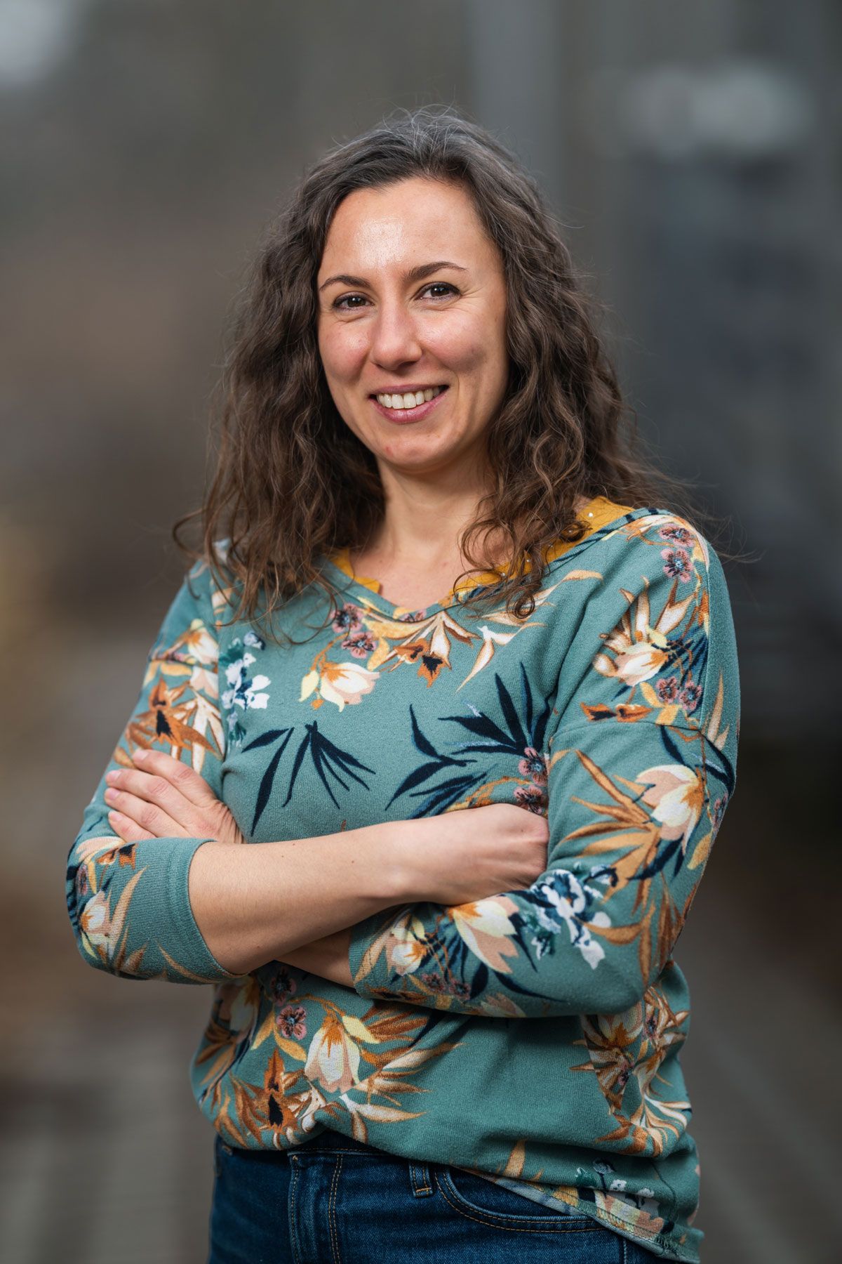 A photo of Giulia Cimarelli studies social behavior of canines at the Domestication Lab of the University of Veterinary Medicine Vienna. She smiles at the camera with her arms crossed.