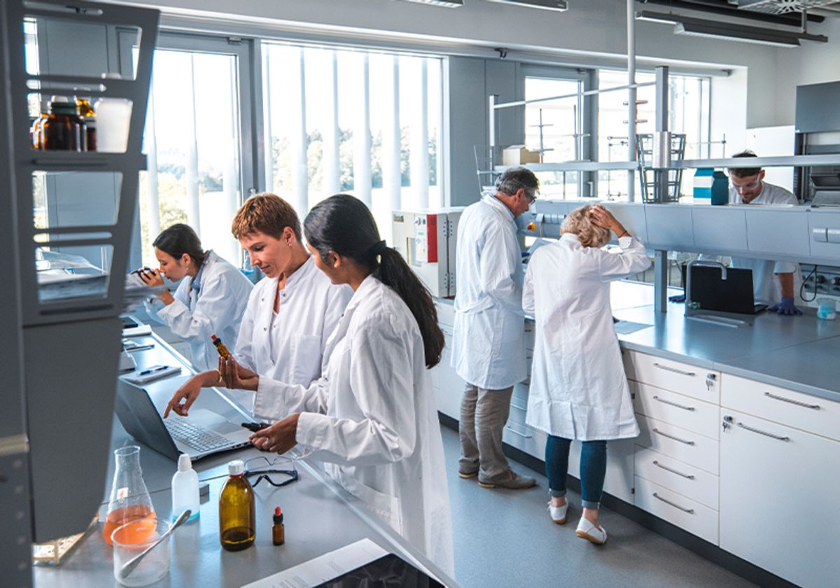 Six researchers wearing lab coats at work in the laboratory