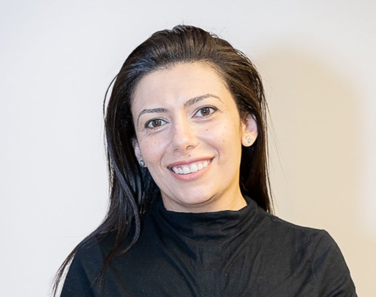 A black-haired woman poses dressed in black 