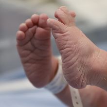 A photo of a newborn baby&rsquo;s feet with a hospital bracelet.