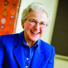 Photo of older woman dressed in blue smiling and looking at the camera