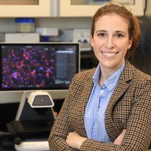 Kaitlyn Sadtler standing in front of a laboratory bench