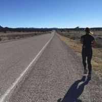 a runner on a road through the desert