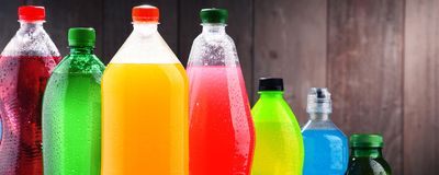 Plastic bottles of assorted carbonated soft drinks in variety of colors.