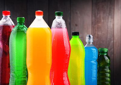 Plastic bottles of assorted carbonated soft drinks in variety of colors.