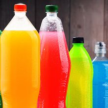 Plastic bottles of assorted carbonated soft drinks in variety of colors.