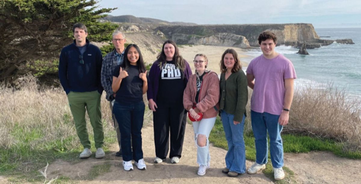 A group of people outside near a beach.