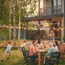 multiple generations of family members eating at outdoor table