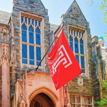 Temple University flag flying in front of a university building