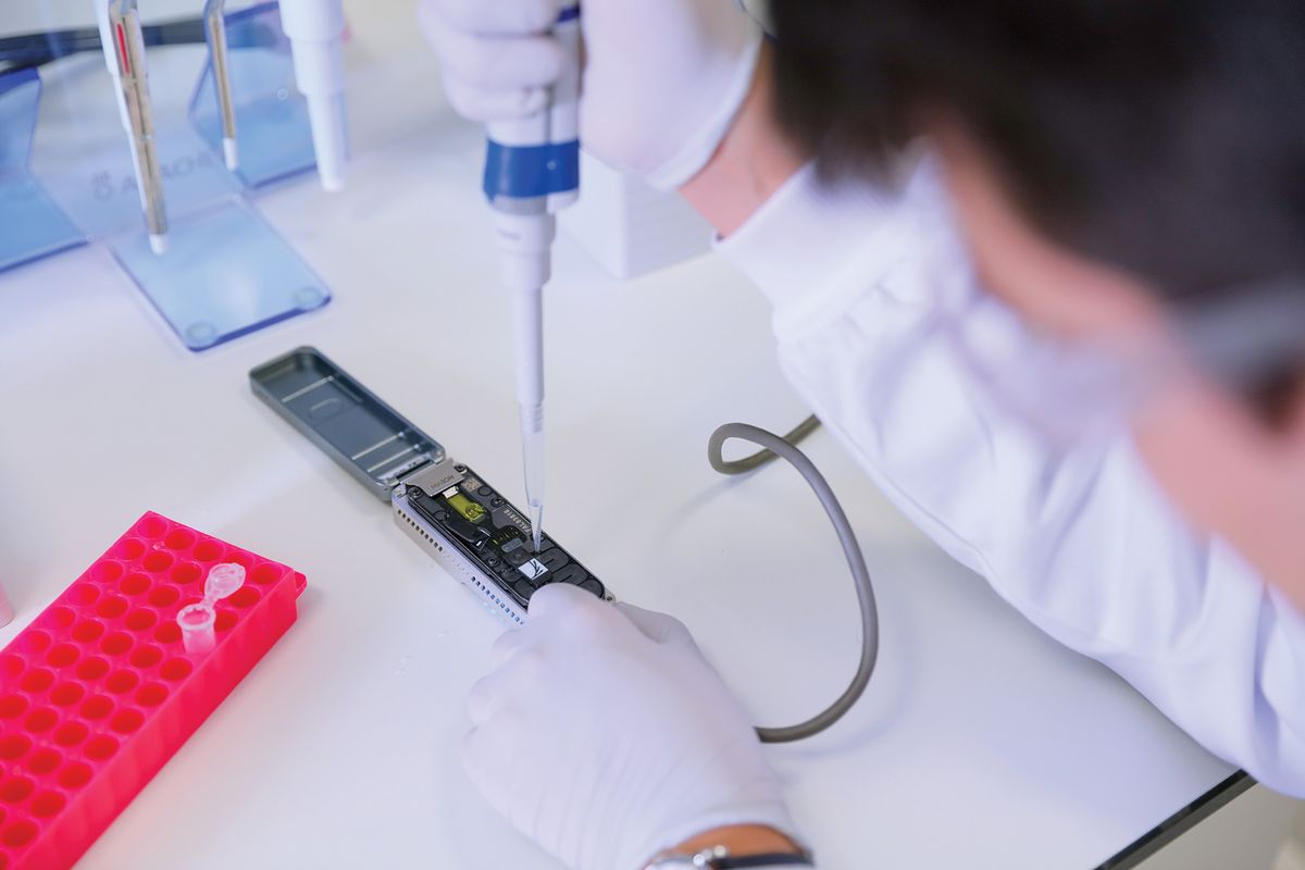 A photo of a scientist loading their prepared library into a flow cell docked within the MinION device.