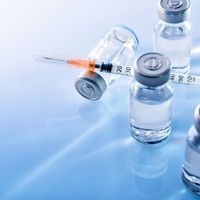 vaccine vials and a needle