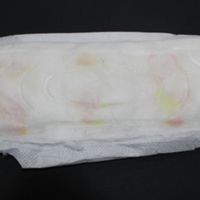 a white menstrual pad with pink and yellow spotting