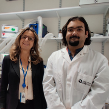 Chiara Zurzolo and Ranabir Chakraborty stand next to a computer monitor displaying a microscopy image