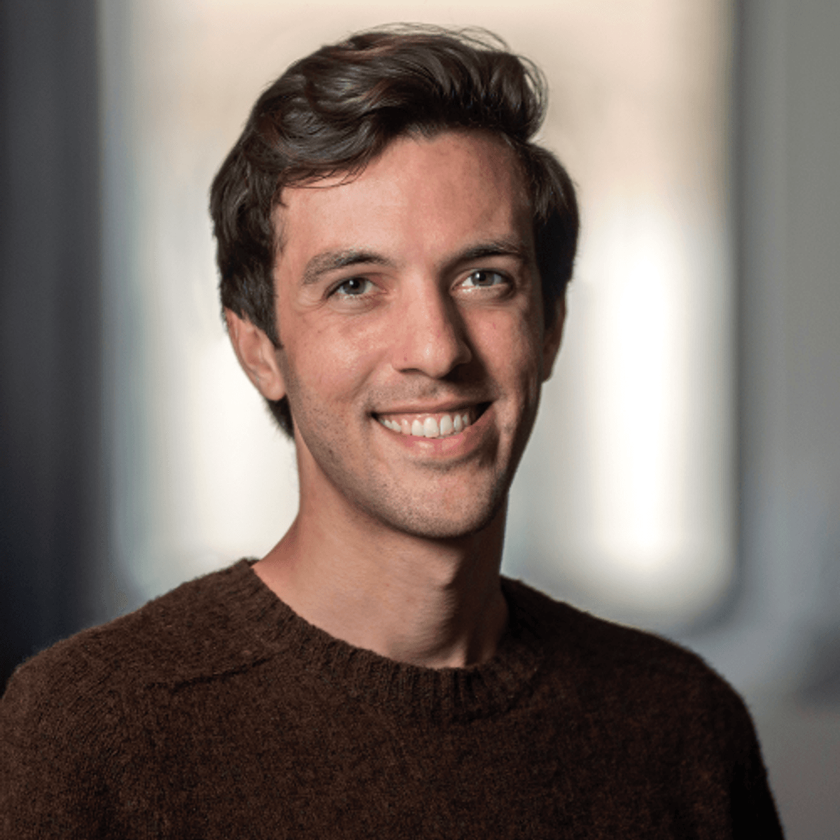 Image of Scott Weady, a research fellow at the Flatiron Institute of the Simons Foundation. He wears a brown sweater and smiles at the camera.